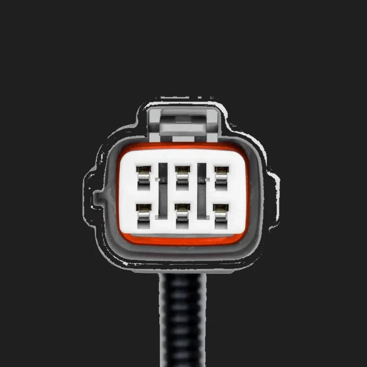 Face of the vehicle-side connector on the Isuzu piggy-back adaptor, a grey moulded shell with an orange seal around a white insert holding six blade terminals