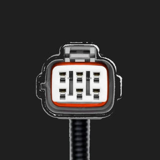 Face of the vehicle-side connector on the Isuzu piggy-back adaptor, a grey moulded shell with an orange seal around a white insert holding six blade terminals