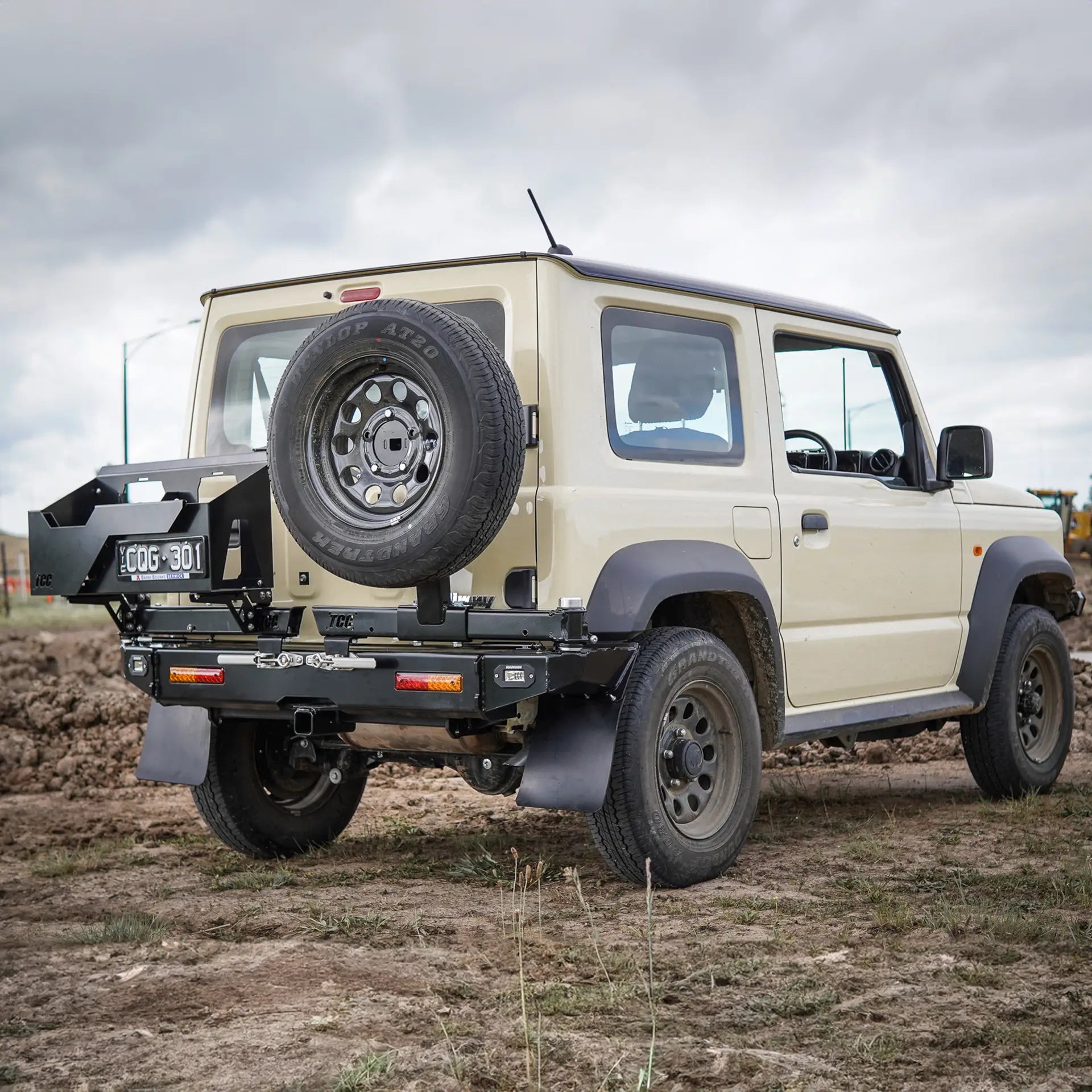 Beige SUV with spare tire on a dirt road