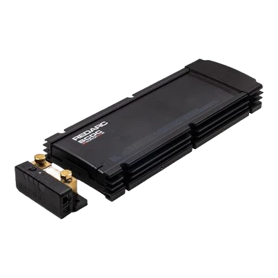 Redarc BCDC Alpha100 R battery manager seen from above at an angle, the long finned black case with the separate battery sense module and its two gold terminal studs sitting alongside