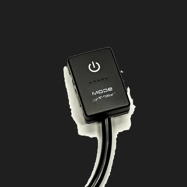 Lightforce MODE touch switch seen at an angle, a black rectangular button with a power symbol, a row of five indicator dots and the MODE by Lightforce name, on a moulded body with a lead leaving the back