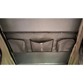 Gray storage compartment with multiple pockets on a vehicle interior – Bush Company LX27 Gen2 Lightweight Clamshell Rooftop Tent