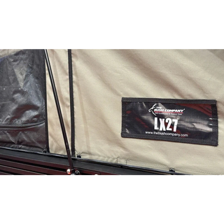 Close-up of a label on a tent with 'The Bush Company' branding and 'LX27' model number.