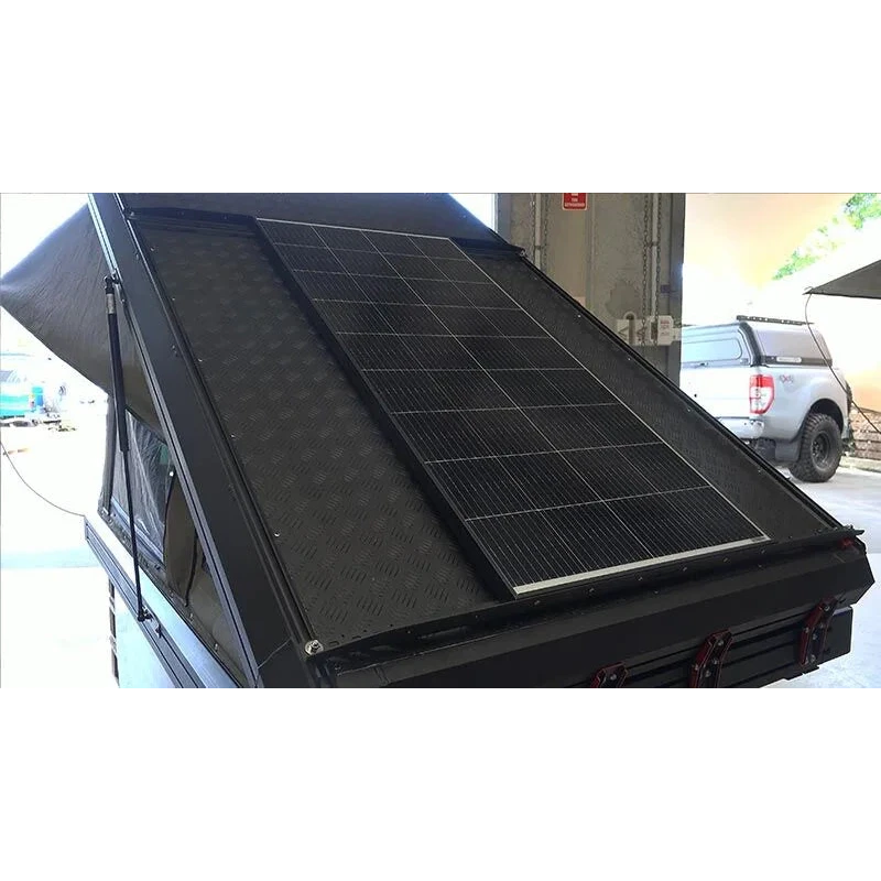 Solar panel on the roof of a vehicle with a building and car in the background