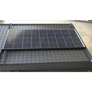 A solar panel mounted flat on a checker-plate canopy roof using the black bracket rails, seen from above with the panel sitting clear of the roof surface