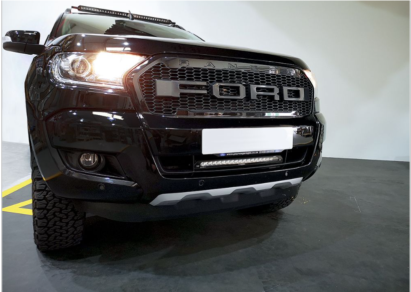 Black Ford Ranger truck front view in a showroom setting with Lazer Lamps Bumper Beam Mount Kit – Ford Ranger (2016–2022)