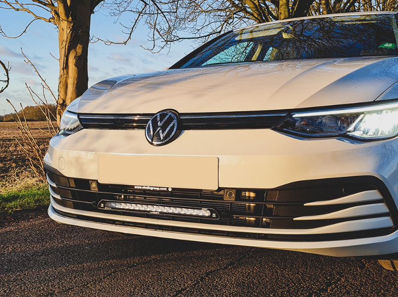Front view of a white Volkswagen car with a clear sky and tree in the background with Lazer Lamps Grille Kit for VW Golf MK8 (2020–2024)