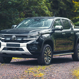 Black Volkswagen pickup truck on a dirt road with greenery in the background with Lazer Lamps Grille Kit for VW Amarok (2023+)