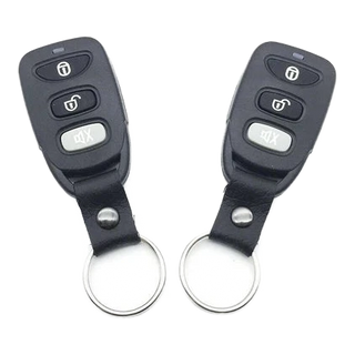 Two black remote controls with keychains on a white background