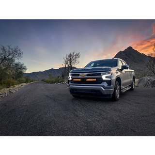 Chevrolet truck on a desert road with mountains in the background