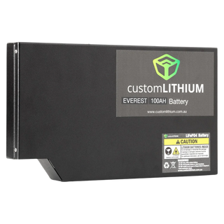 The Custom Lithium Everest 100Ah battery from the front corner, the moulded step in the base that clears the vehicle floor, the product label and the LiFePO4 caution label on the face