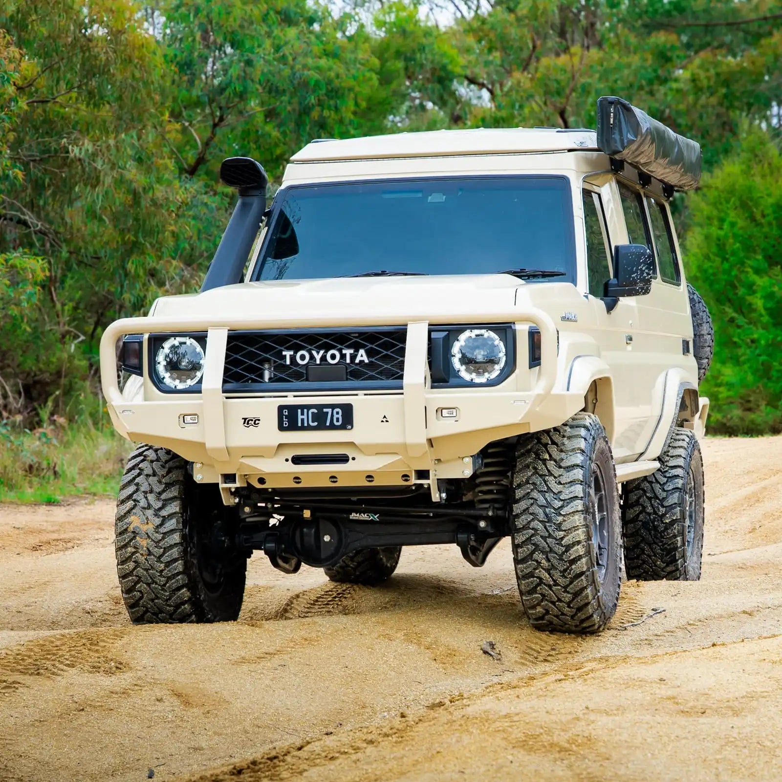 Toyota off-road vehicle on a dirt road with trees in the background
