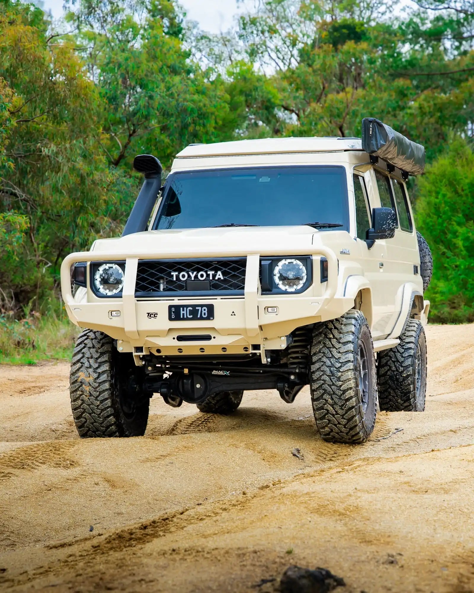 Toyota off-road vehicle on a dirt road with trees in the background
