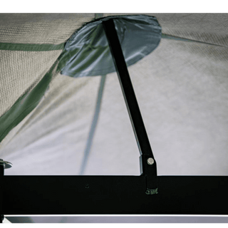 Close-up of a tent mesh with a pole and brand logo.