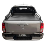 Back view of a silver Mitsubishi truck with a tonneau cover on a white background