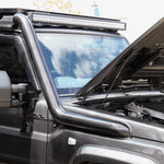 Close-up of a vehicle with a roof rack and LED light bar, outdoors.