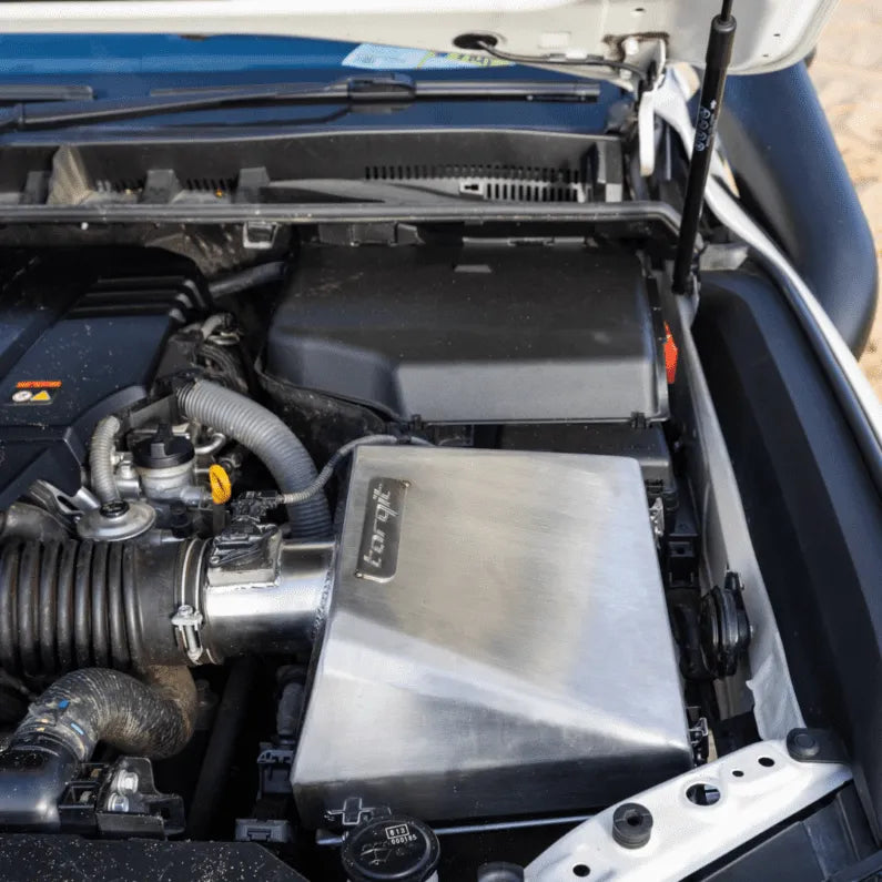 Car engine compartment with open hood showing various components.