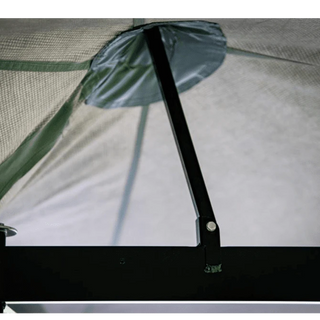 Close-up of a tent mesh with a pole and brand logo.