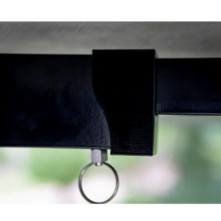 Close-up of a black strap with a metal ring attachment against a blurred green background