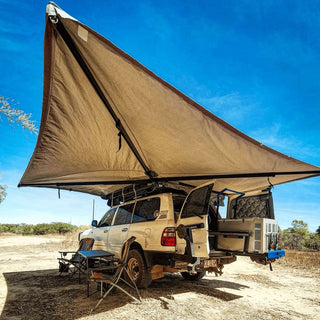 Camper van with an extended roof tent in a desert setting