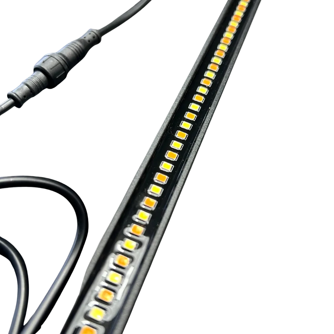 Close up of the Elevate dual colour LED strip light showing the alternating amber and white LEDs down the housing and the inline waterproof connector on the lead