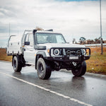White Toyota truck on a road with a cloudy sky