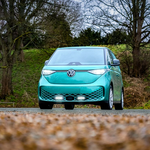 Turquoise electric car on a road with trees and grass in the background with Lazer Lamps Grille Kit for VW ID Buzz (2025+)