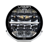 A black 7-inch Lazerlamps Sentinel LED driving light with a clear polycarbonate lens, designed for vehicles or tight mounting setups, featuring advanced LED technology.