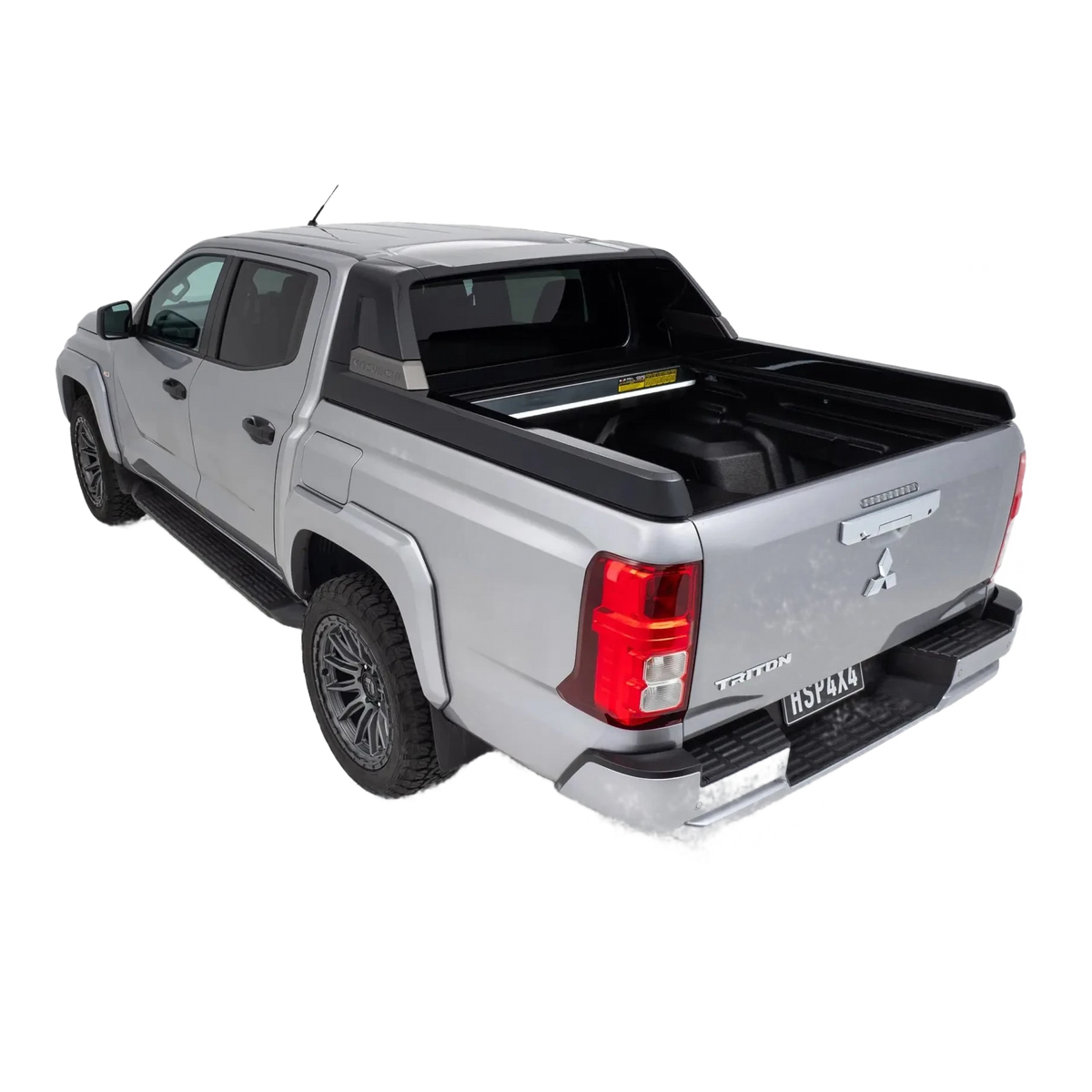 Silver Mitsubishi Triton pickup truck with a black tonneau cover on a white background