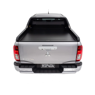 Back view of a silver Mitsubishi Triton pickup truck with a tonneau cover on a white background