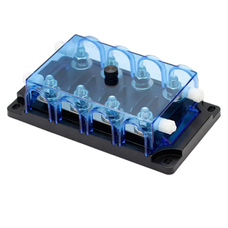 The four-bay mega fuse holder with its clear blue cover fitted, the fuses and studs visible through the lid, with white insulating spacers at the outer terminals