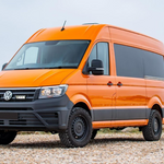 Orange Volkswagen van on a gravel road with a clear sky background with Lazer Lamps Grille Kit for VW Crafter (2017+)