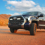 Toyota truck on a dirt road with mountains in the background with Lazer Lamps Grille Kit – Toyota Tundra Platinum (2022+)