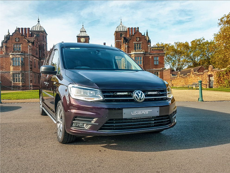 Volkswagen van parked in front of a historic building with trees in the background with Lazer Lamps Grille Kit for VW Caddy (2015–2019)