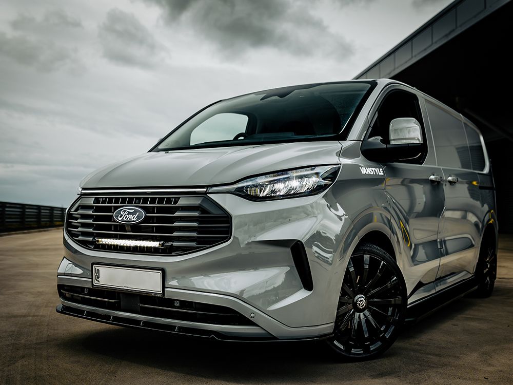 Silver Ford van parked on a road with a cloudy sky in the background with Ford Transit Custom (2024+) Grille Kit
