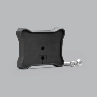 Black moulded flat mount for a rock light seen at an angle, the ribbed rear face with a cable hole and a slotted opening, with two stainless button-head screws laid beside it