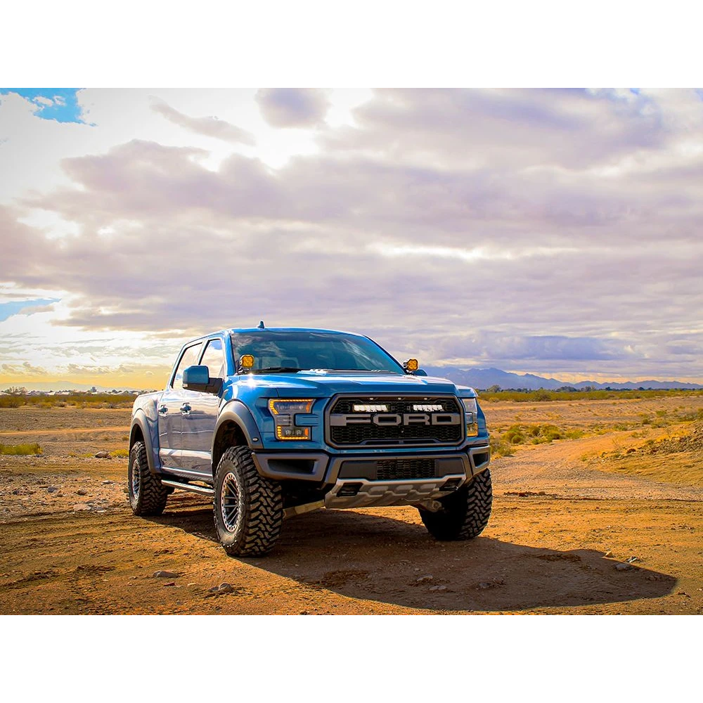 Ford F-150 Raptor (2017-2020) Grille Kit – blue Ford truck on a desert road with a cloudy sky