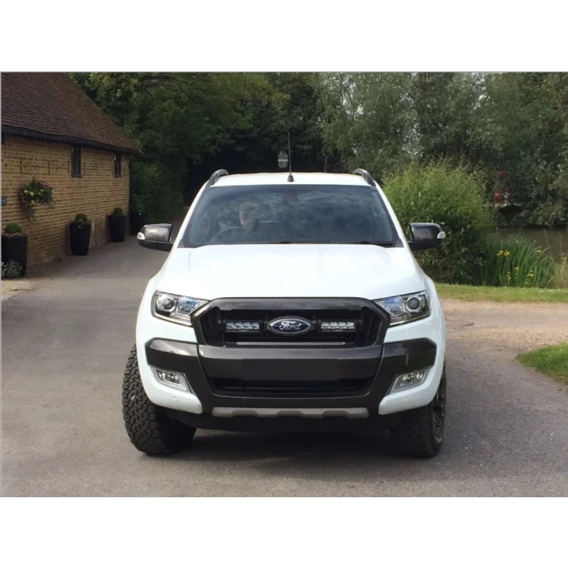 White Ford ranger with Lazer Lamps Grille Kit (2016–2018) parked on a driveway with a house and trees in the background