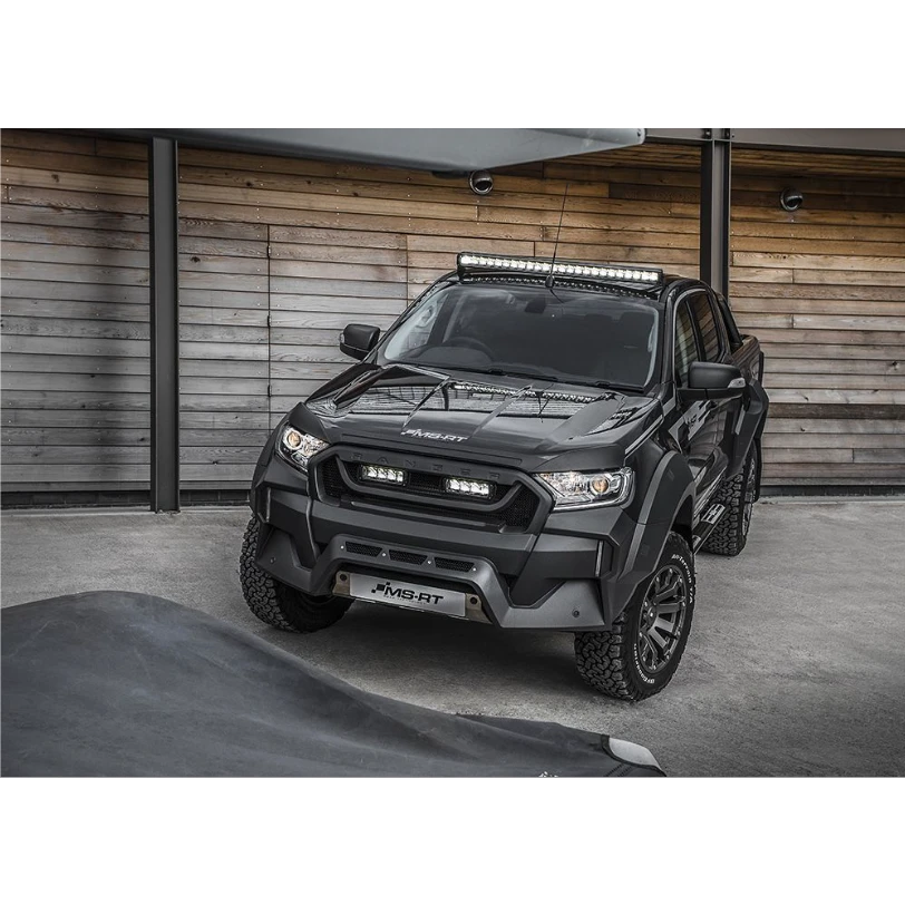 Black off-road vehicle with additional Lazer Lamps Roof Mount Kit – Ford Ranger (2016+ No Roof Rails) lights in front of a wooden wall.