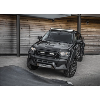 Black off-road vehicle with additional Lazer Lamps Roof Mount Kit – Ford Ranger (2016+ No Roof Rails) lights in front of a wooden wall.