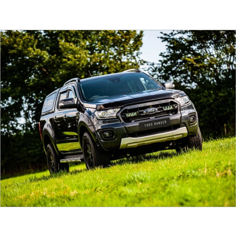 Black Ford Ranger with Lazer Lamps Grille Kit – Ford Ranger (2019–2022) on a grassy field with trees in the background
