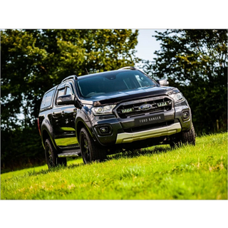 Black Ford Ranger with Lazer Lamps Grille Kit – Ford Ranger (2019–2022) on a grassy field with trees in the background