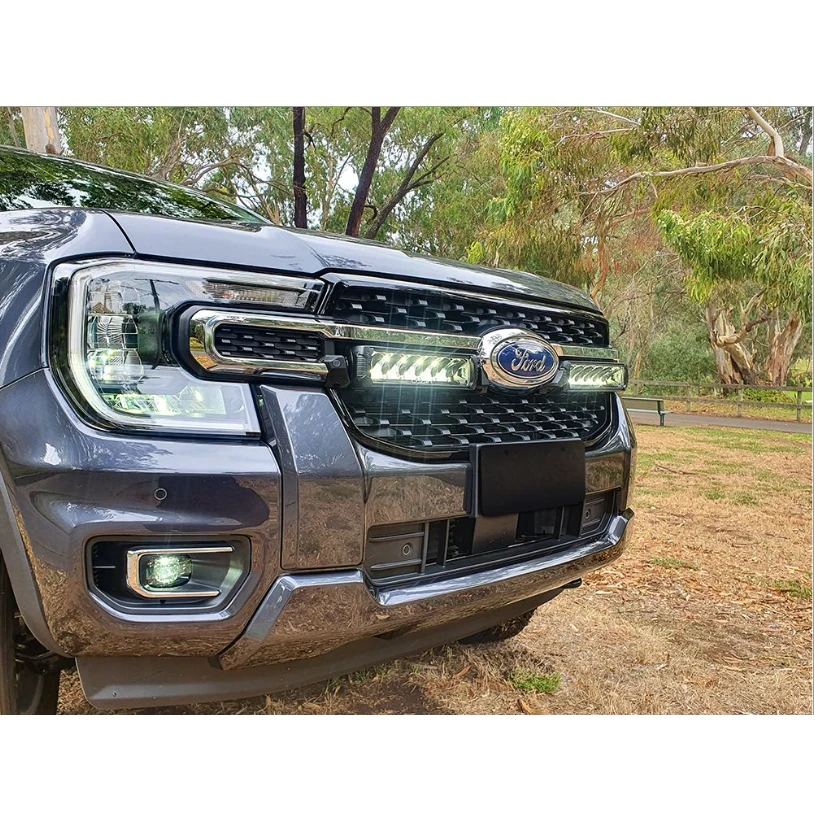 Ford vehicle grille with lazerLamps Grille Kit and trees in the background