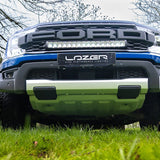 Front view of a Ford truck with Lazer performance lighting system on a grassy area.
