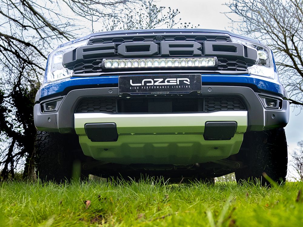Front view of a Ford truck with Lazer performance lighting system on a grassy area.