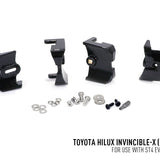 Set of black metal brackets and screws for Toyota Hilux Invincible-X on a white background