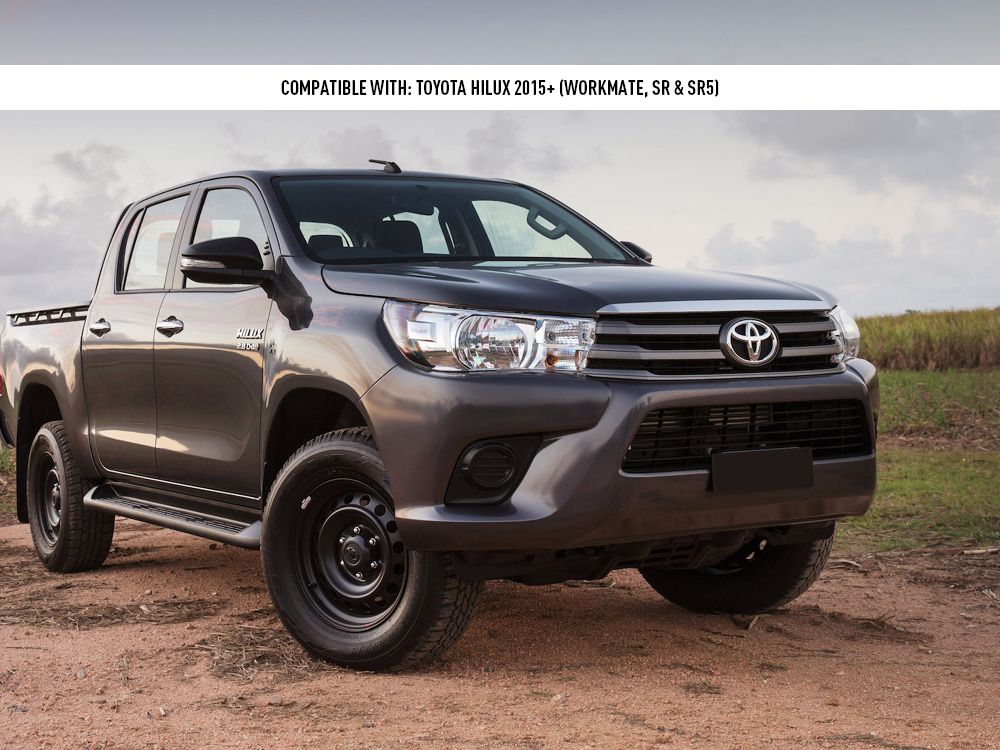 Gray Toyota Hilux pickup truck on a dirt road with a cloudy sky in the background.