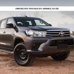 Gray Toyota Hilux pickup truck on a dirt road with a cloudy sky in the background.