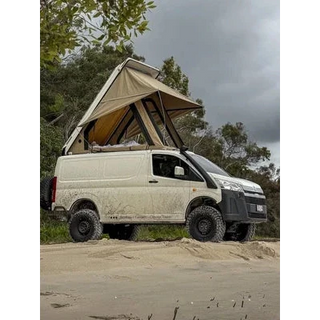 Van with a rooftop tent parked on a dirt road surrounded by trees – Headspace Roof Conversion HiAce