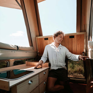Inside a Troopy with the Headspace roof raised, showing the timber-lined interior and standing room